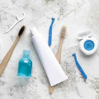 various toothbrushes, floss and toothpaste on marble top
